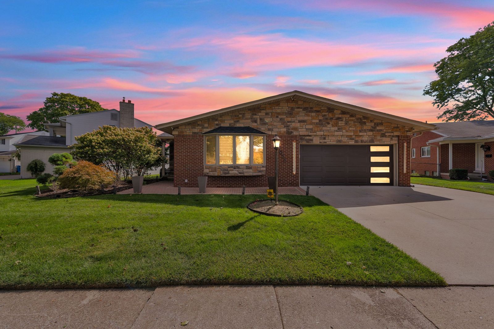 27033 Timber Trail, a stone-and-brick ranch in Dearborn Heights, at twilight